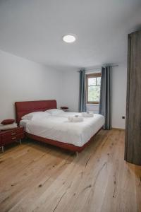 伊德里亚Chalet HerMes arT的一间卧室设有一张大床,铺有木地板