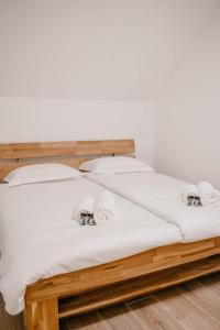 伊德里亚Chalet HerMes arT的一张带白色床单和枕头的木床