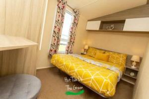 塔特舍尔Home from Home Lettings at Tattershall Lakes - The Green的一间卧室设有黄色的床和窗户。