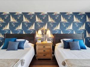 佩托斯基BreathTaking LakeViews DTPetoskey Work Desk的卧室内的两张床,配有帆船壁画
