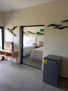圣米格尔Kuluka Resort And Spa的一间卧室配有一张床,墙上有一面镜子,上面有鸟儿