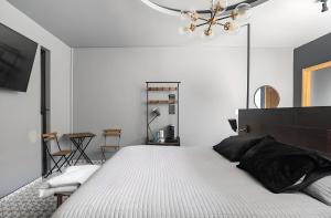 恩塞纳达港The Studios 22800的卧室配有一张白色大床和吊灯。