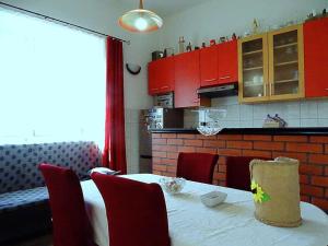 拉斯托伏Studio Apartman Ana的厨房配有红色橱柜和白色桌椅