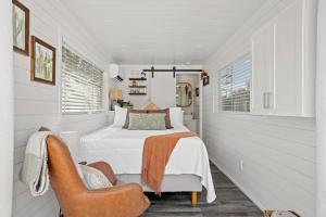 弗雷德里克斯堡New The Saguaro-Tiny Shipping Container Home的白色卧室配有床和椅子