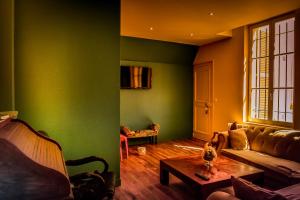 圣梅内乌勒德莫尔达贡住宿加早餐旅馆的客厅设有绿色的墙壁、一张沙发和一张桌子