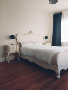 恩尼斯克朗Grá na Farraige的一间卧室配有白色的床和两张床头柜。
