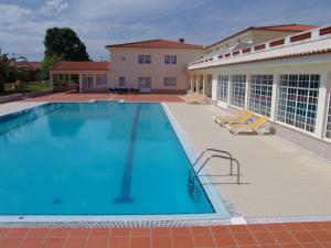 圣地亚哥-杜卡森Quinta de Malmedra的一座带椅子的大型游泳池和一座建筑