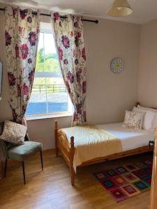基尔拉什Beechwood View的一间卧室设有一张床、一个窗口和一把椅子