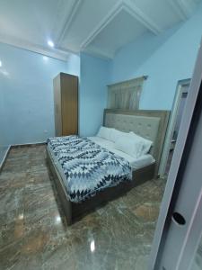 JiduDazzle Hotels and Apartments的蓝色客房中一间带床的卧室