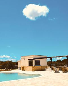 科里利亚诺多特兰托Agriturismo Le Site的一座带游泳池的房子上方一片云