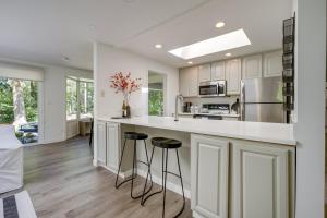 伍丁维尔Modern Home 3 Miles to Woodinville Wine Country!的厨房配有白色橱柜和带凳子的台面