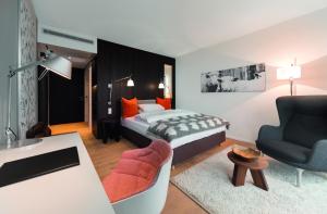 罗伊特林根阿卡尔姆酒店的一间卧室设有一张床和一间客厅。