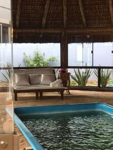 弗洛里亚诺波利斯Essência do Sol Pousada的带沙发和游泳池的客厅