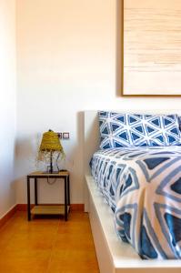 拉奥利瓦140 Oltre Majanicho by iRent Fuerteventura的一间卧室配有一张床和一张带台灯的桌子
