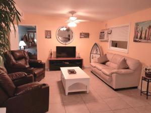 Greenacres CitySusan and Ledif's Tropical Hideaway的客厅配有两张沙发和一台电视机