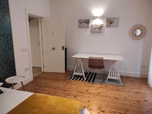 莱昂Lujoso y amplio apartamento.的客房设有桌子和床,铺有木地板。
