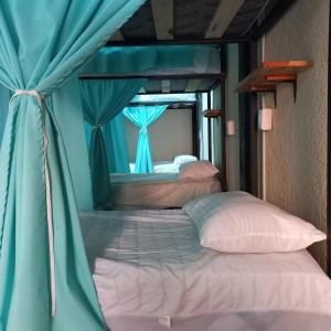 埃斯孔迪多港Chante的一间卧室配有两张带蓝色窗帘的床