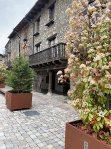 贝尔维尔德赛当亚CAL JAN - La Muralla的一座砖砌建筑,设有阳台,并种植了植物