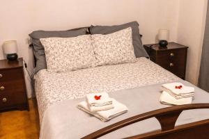 EstanqueiroQuinta dos Pinheiros的一间卧室配有带毛巾和2个床头柜的床