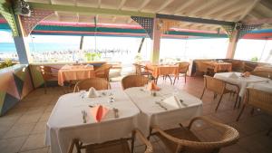 弗利盖特湾提摩海滩度假酒店的一间设有白色桌椅的海洋餐厅