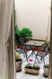 亚历山德鲁波利斯Hermes Modern Apartment的天井配有桌椅和盆栽植物