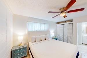德斯坦Gulf Terrace Unit 147的一间卧室配有一张床和吊扇