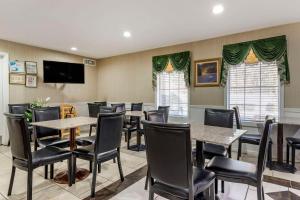 科尼尔斯Quality Inn Conyers I-20的餐厅设有桌椅和平面电视。