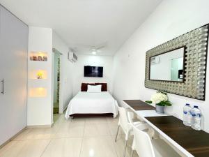 巴兰基亚Aparta estudios nuevos Mubarak的一间卧室配有一张床、一张桌子和一面镜子