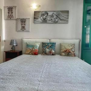 恩佩多克莱港LA TERRAZZA SUL MARE的卧室配有一张墙上三幅照片的床