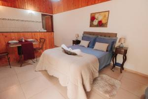 佩尼多Chalé das Carpas的一间卧室配有一张床和一张桌子,上面放着碗