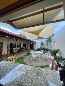 JuayúaHostal DEYLUWIN的庭院配有白色的桌椅和遮阳伞。