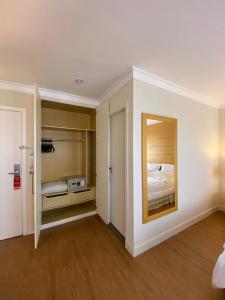 圣保罗Hotel Aeroporto Congonhas的客房设有带镜子和床的卧室