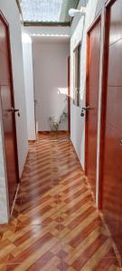 帕拉卡斯POSADA MIS 3 BENDICIONES的空的走廊,铺有木地板,设有门