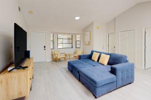 迈尔斯堡Bahama Breeze的客厅配有蓝色的沙发和电视