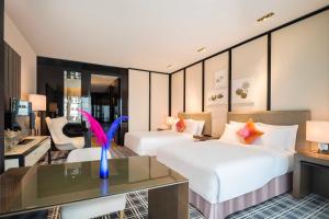 广州W Guangzhou的酒店客房配有两张床和一张书桌