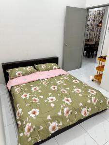 加央Aisy Guest House - MUSLlM Only的一间卧室配有一张带绿色和粉色毯子的床