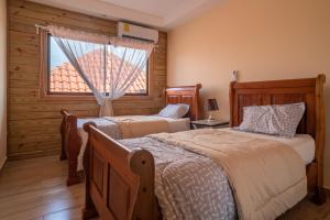 La EstrellaLoft con terraza en Santo Domingo的一间卧室设有两张床和窗户。
