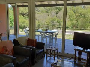 坦迪尔Casa de Campo con Bosque y Pileta的客厅配有电视和桌椅