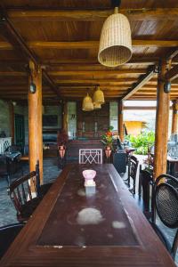 Làng CacTớ Dày Du Già Village的配有椅子的房间里一张大木桌