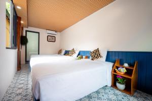 吉婆岛Catba Papillon Garden Bungalows & Resort的蓝色和白色的客房内的两张床