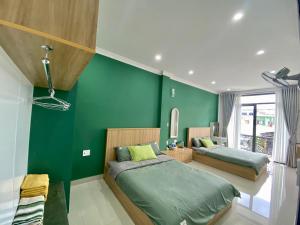 保禄SÂM LÂM HOUSE - Bảo Lộc的一间卧室设有两张床和绿色的墙壁