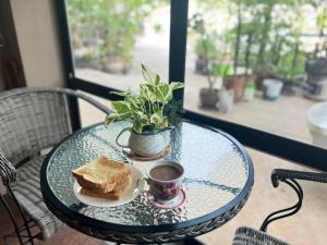 乌隆他尼V Tharm Hotel的一张桌子,上面放着三明治和一杯咖啡
