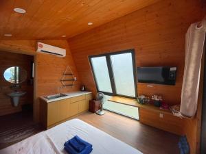 嘎那角Tân Thành Resort的卧室设有大窗户、水槽和电视。