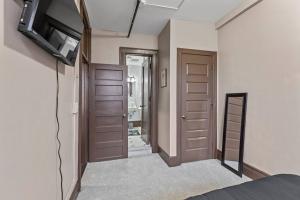 锡拉丘兹Perfect Blend of Convenience & Comfort Syracuse NY的带2扇门、电视和浴室的客房