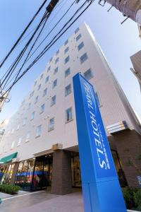 东京Pearl Hotel Shinjuku Akebonobashi的前面有蓝色标志的建筑