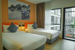 曼谷The Iconic Hotel Don Mueang Airport的酒店客房设有两张床和窗户。