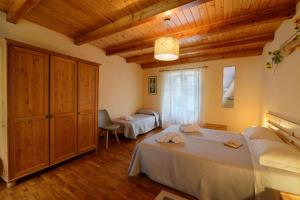 Villar PelliceBed & Breakfast Ai Fontana的一间卧室设有两张床和木制天花板