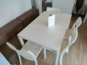 RonchiGarda Di Vino Agricamping & Wine Shop Lazise的客厅配有一张白色的桌子和两把椅子