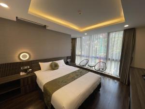 河内3T Hotel Hanoi的一间卧室设有一张大床和一个大窗户