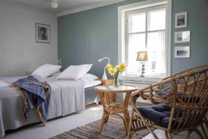 赫尔辛基Seaside Cottage in Suomenlinna的卧室配有1张床、1张桌子和1把椅子